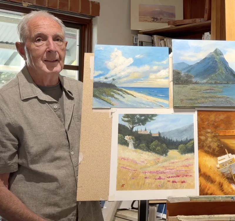Mark Price beside his paintings